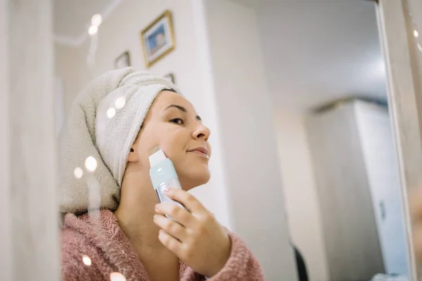 Reflejo de una mujer exfoliándose la cara con limpiador de poros — Foto de Stock