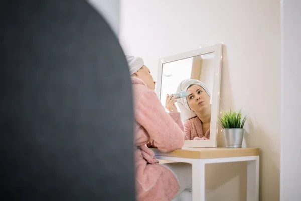 Señora limpiando su cara en mesa de madera con espejo — Foto de Stock