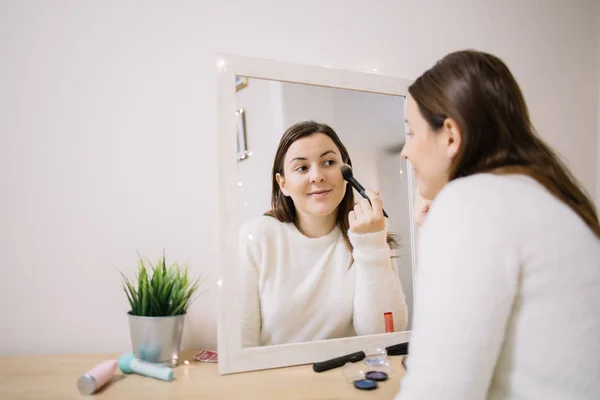 Maquillaje de mujer feliz delante de un espejo — Foto de Stock