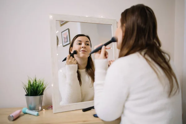 Reflejo de una mujer maquillándose con un cepillo rubor — Foto de Stock