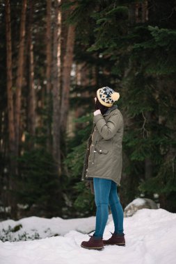 Ormanda karda yürüyen bir kadın.