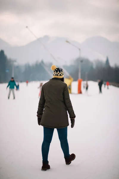 눈덮인 산을 걷고 있는 소녀의 뒷모습 — 스톡 사진