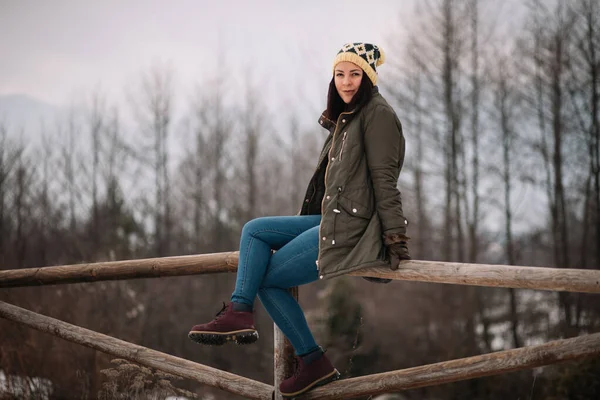 숲 속 의나무 울타리 위에 있는 젊은 여자 — 스톡 사진