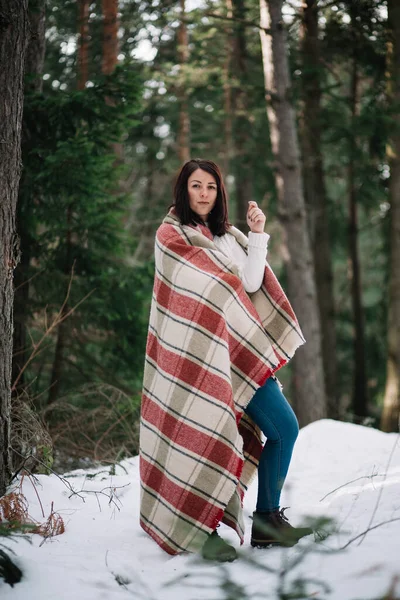 Brunette fille se réchauffe avec une couverture en forêt — Photo