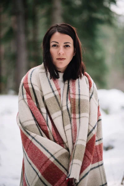 Belle femme couverte de couverture dans la forêt enneigée — Photo