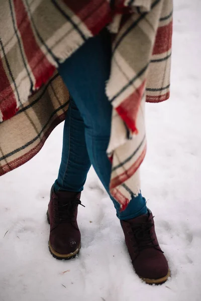 Crossed female legs in jeans on snow — Stockfoto