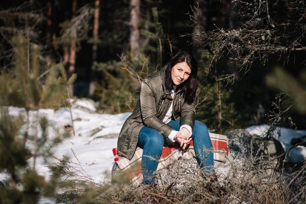 Smiling girl looking at camera while sitting in woods — Zdjęcie stockowe