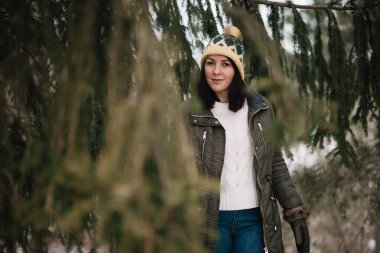 Pretty woman between tree branches in winter