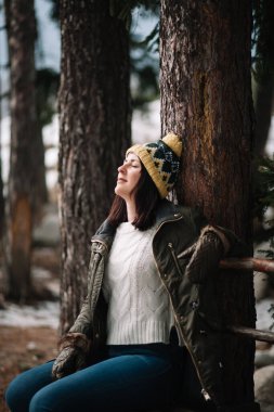 Attractive girl enjoying nature while sitting on a bench