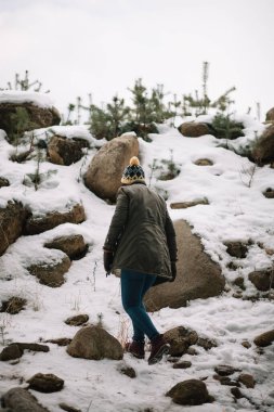 Back of a woman hiking snowy hill