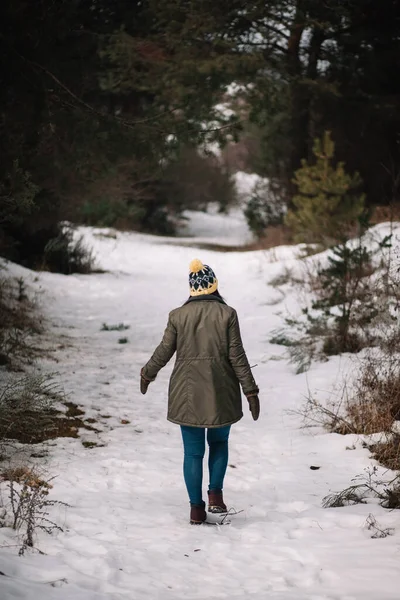 Lonely woman walking on snowy winter road — Stock fotografie