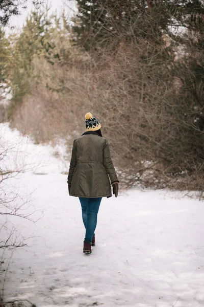 Back of a woman walking in snow in winter clothes — 스톡 사진