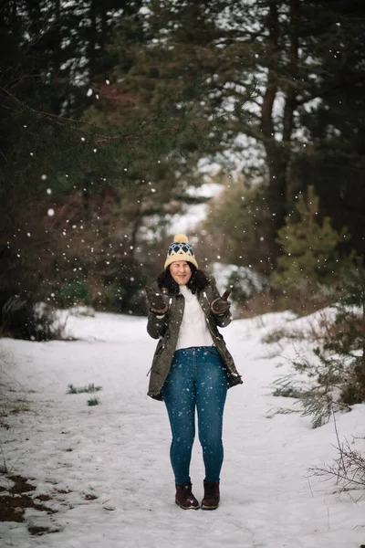 Woman throwing snow in the air in winter forest — 스톡 사진