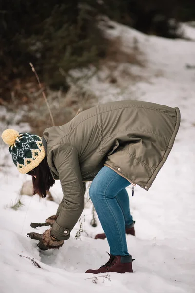 Girl bending down in a snowy forest — Φωτογραφία Αρχείου