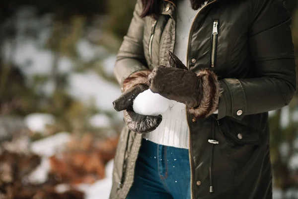 Mani femminili con guanti che fanno una palla di neve — Foto Stock