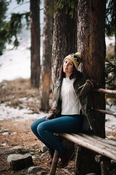 Woman sitting on wooden bench in the park — Stockfoto