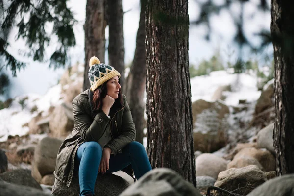 Chica bonita sentada sobre piedras en el bosque — Foto de Stock
