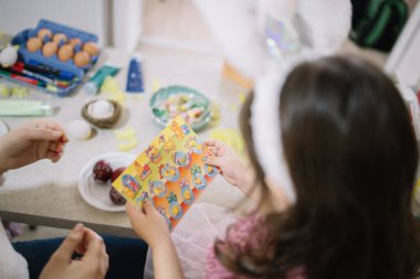 Childs hands holding Easter stickers for egg decoration