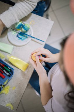 Top view of childs hands holding decorated egg