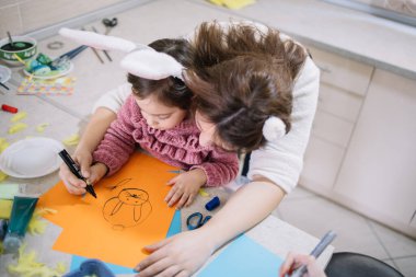 Mother teaching her little girl how to draw