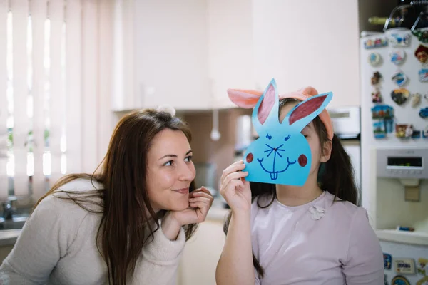 Happy mother looking at her child with bunny over her face — Stockfoto