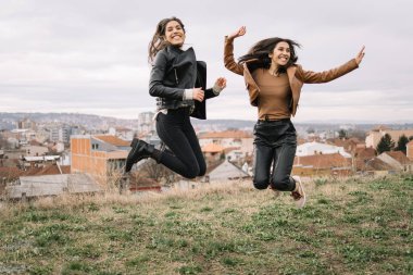 İkiz kardeşler gülümsüyor ve havada zıplıyorlar.