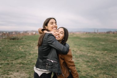 Güzel kız kardeşler gün boyunca parkta sarılıyorlar.