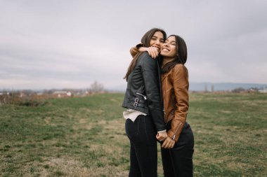 Parkta sarılan iki mutlu kız kardeş.