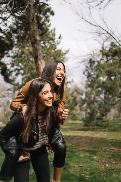 Две сестры-близнецы веселятся в парке — стоковое фото