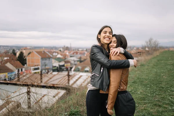 Брюнетка обнимает свою сестру за холмом — стоковое фото