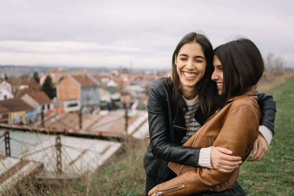 Kvinnliga vänner träffas och kramas på kullen — Stockfoto