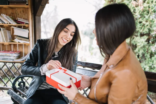 Femme heureuse regardant dans un cadeau en plein air — Photo