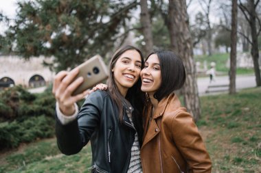 Kız kardeşler telefona gülümsüyor ve selfie çekiyorlar.