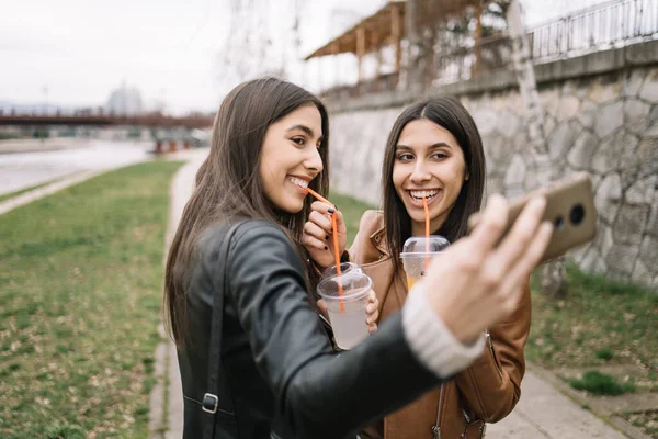 Kobiety pijące drinki na świeżym powietrzu i robiące selfie — Zdjęcie stockowe