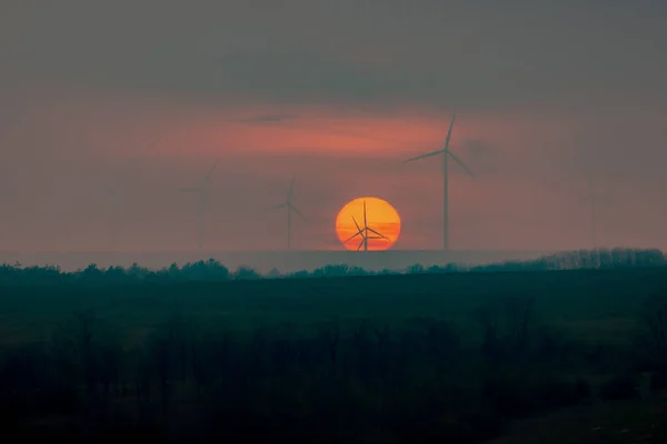 Silhouette de moulin à vent devant un coucher de soleil — Photo