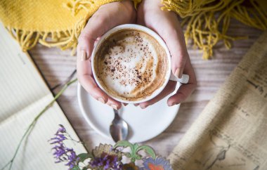Kadın ellerinin kapuçino tutuş görüntüsü