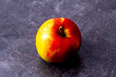 Çizik siyah dokuya karşı tek taze elma.