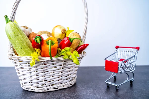 Keranjang dengan sayuran dekat keranjang belanja kecil — Stok Foto