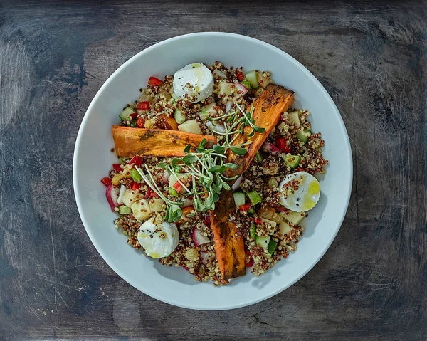 Salad with quinoa, carrots, cheese and sprouts