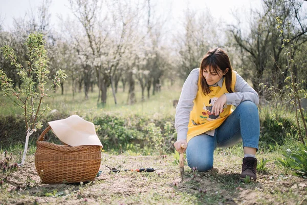 Wanita duduk di halaman belakang dengan alat berkebun — Stok Foto