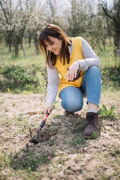 Gadis cantik menggunakan alat berkebun di halaman — Stok Foto