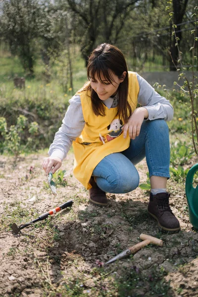 Gadis dengan tangan berkebun sekop di kebun sayuran — Stok Foto