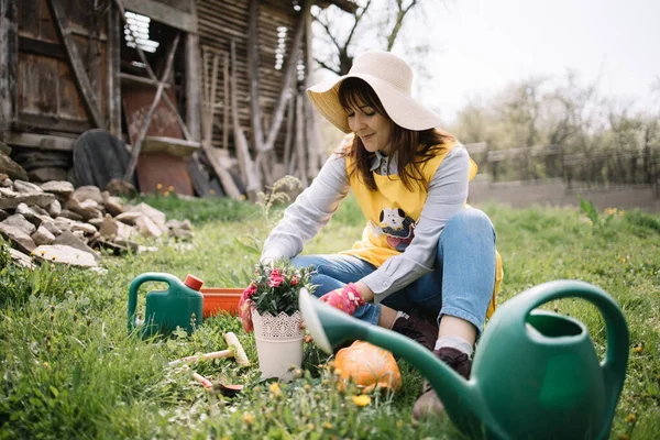 Wanita bahagia menanam sambil duduk di tanah dengan alat berkebun — Stok Foto