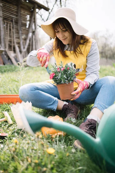 Wanita muda tukang kebun menanam bunga di taman — Stok Foto