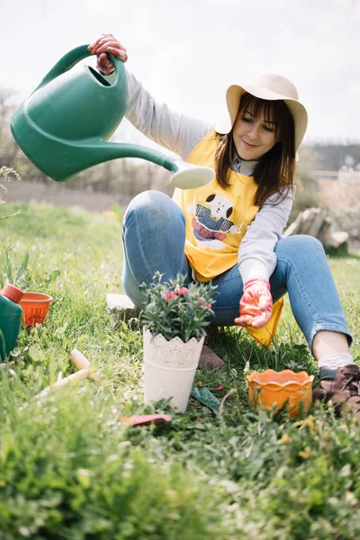Senyum wanita memegang air bisa lebih dari pot dengan bunga — Stok Foto