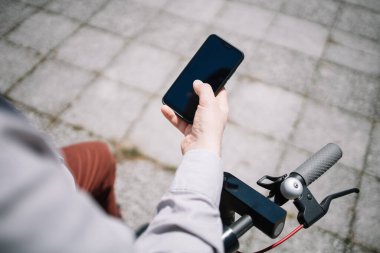 Beyaz ekran ile siyah akıllı telefonu tutan insanlar