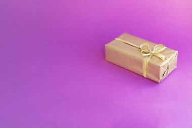 Fiyonklu altın kutu. Renkli pembe arka planda bir hediye. Her amaç için harika bir tasarım. Moda, cazibe arka planı. Yeni yıl, Noel tasarımı.
