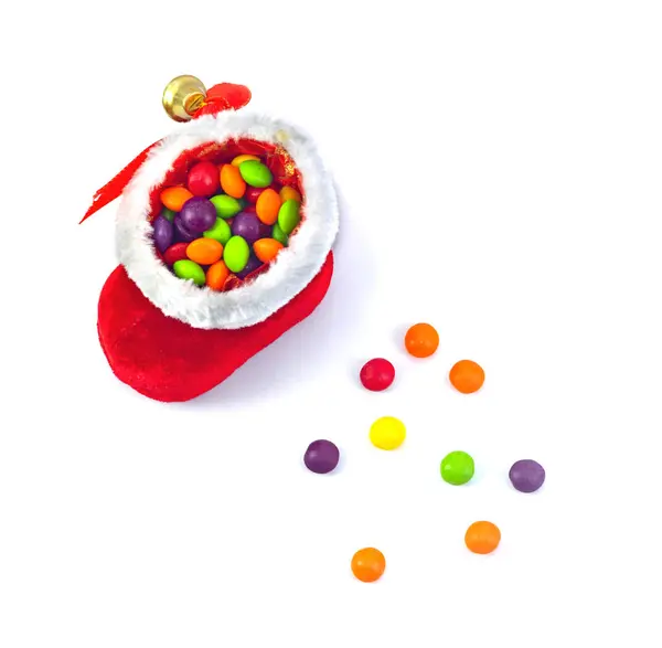 Multi-colored colored small sweets scattered from a Christmas boot. White background — Stock Photo, Image