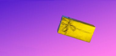Üzerinde yay sinekleri olan altın kutu havalanır. Renkli pembe arka planda bir hediye. Her amaç için harika bir tasarım. Moda, büyüleyici bir arka plan.