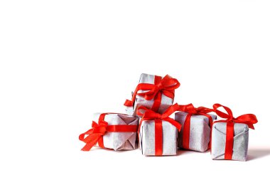 El işi kağıdına sarılı hediye kutuları ve sarı arka planda kırmızı saten kurdele. Bahar, bir kadın için bir hediye, tatil havasından bir hediye. Yeni yıl Noel dekoru. Popüler eğilim